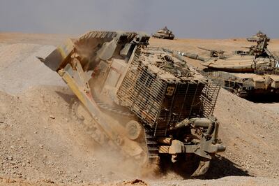 An armoured Caterpillar D-9 clearing the way for Mark IV main battle tank during an exercise. Alamy