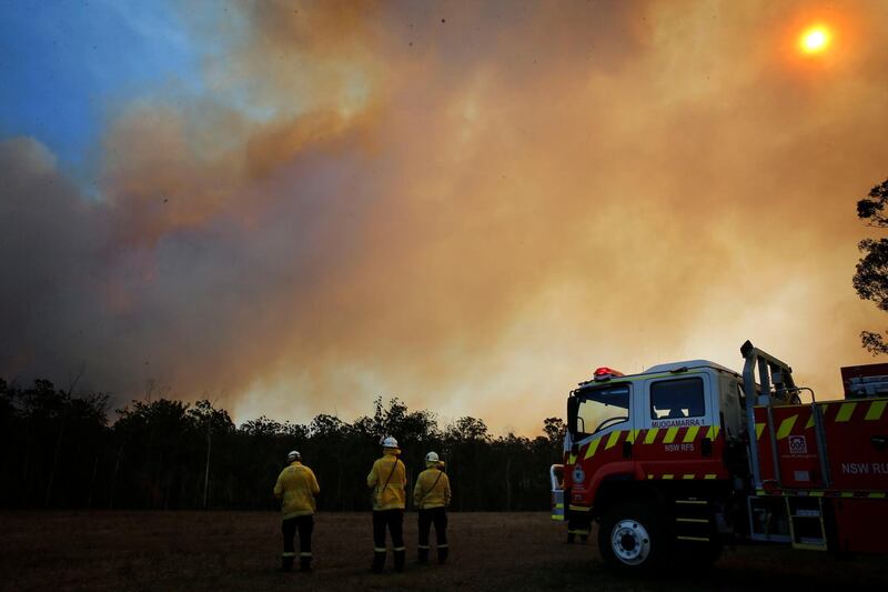 Firefighters look at a bushfire approaching in Old Bar, New South Wales, Australia.  EPA