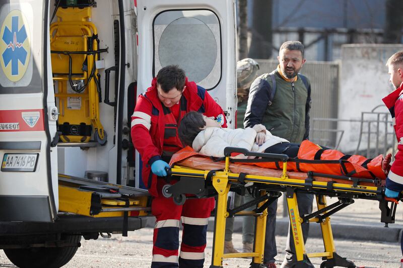 Medical specialists transport a woman, who was wounded in the shelling of an apartment building, to an ambulance, as her husband looks on. Reuters