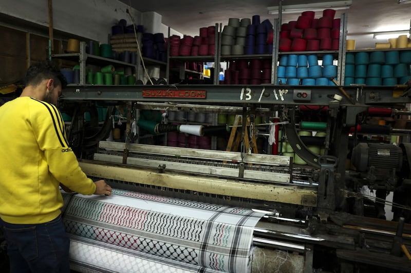 A worker stands over a loom at the Hirbawi textile factory producing the Palestinian Keffiyeh scarf in the occupied West Bank city of Hebron. AFP