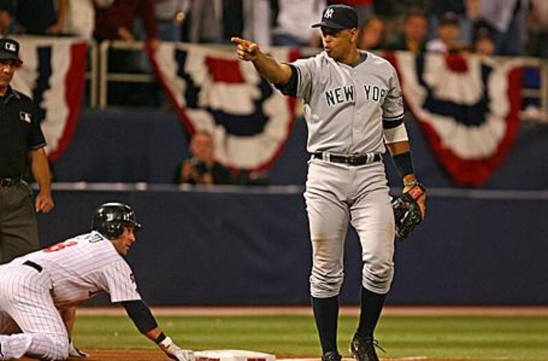 Alex Rodriguez points to a teammate after tagging out the Twins' Nick Punto at third.