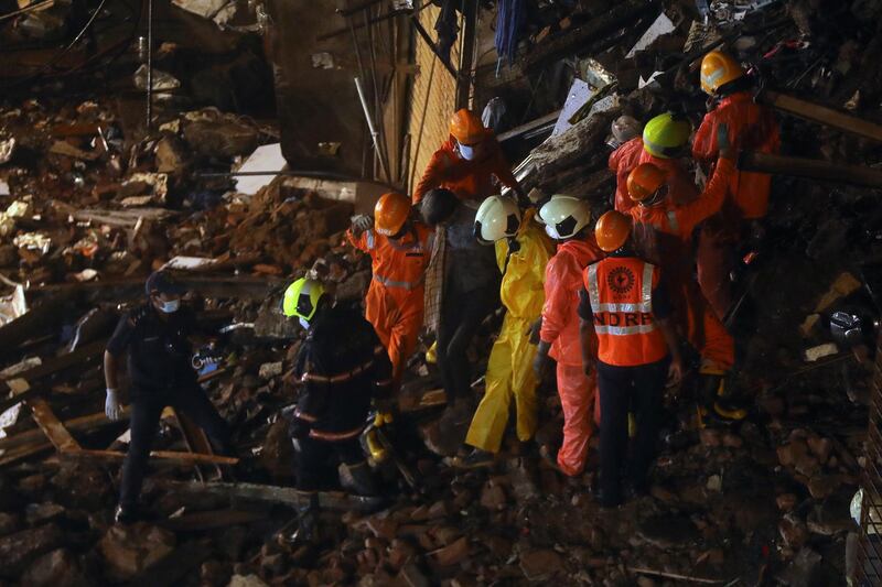 National Disaster Response Force and fire brigade personnel help a man rescued from the rubble. Reuters