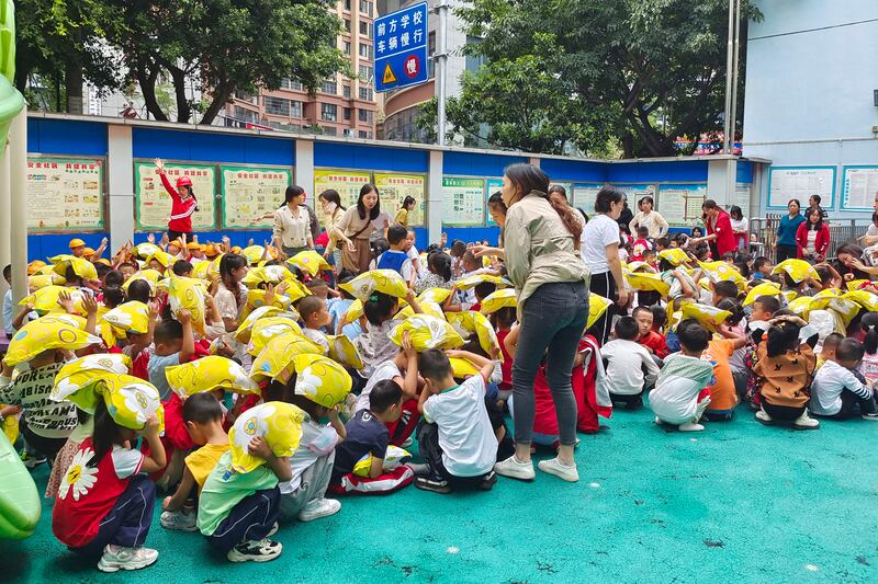 Children sit at playground in the city of Yaan, after being moved outside as a precaution. Xinhua News Agency/AP