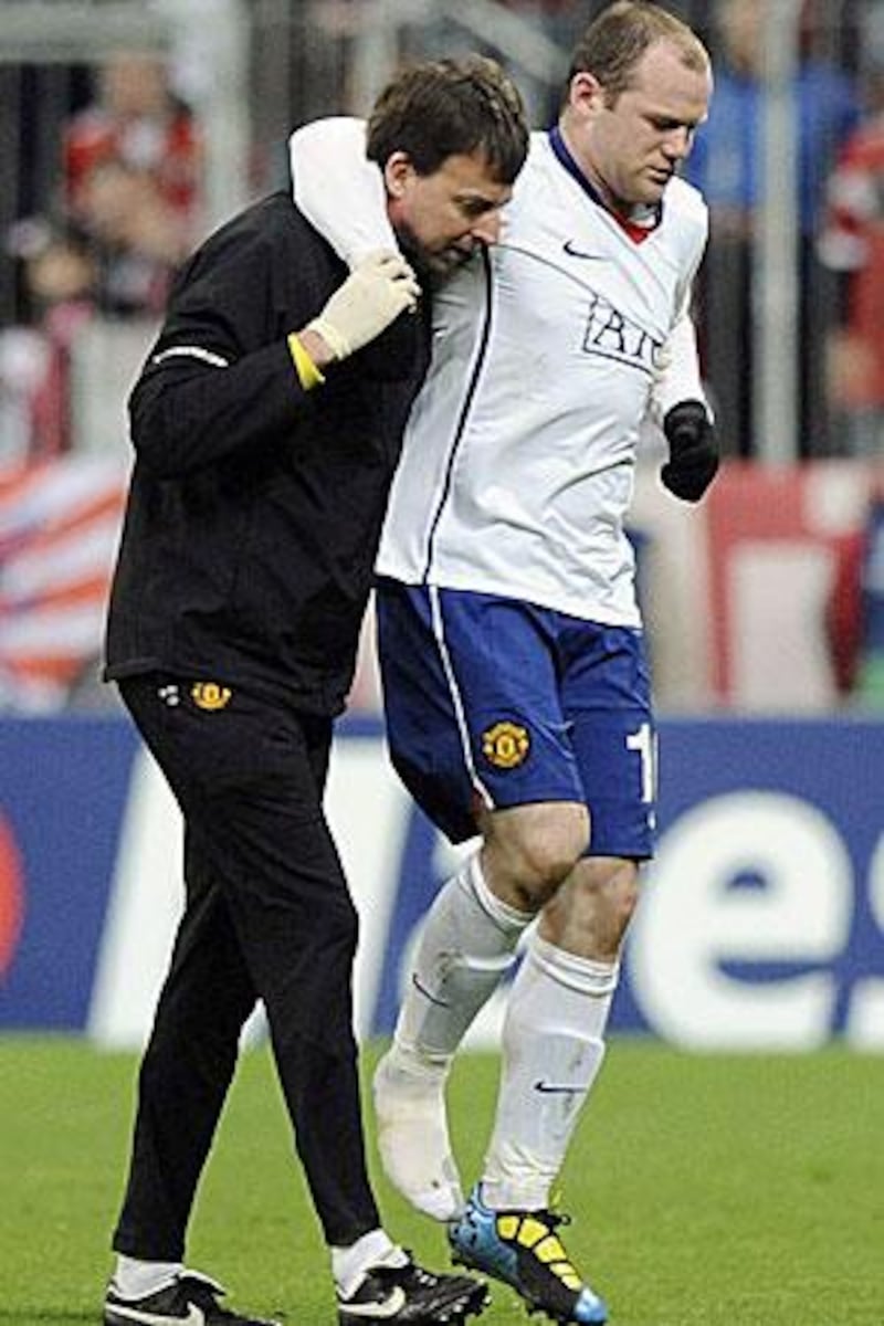 Manchester's Wayne Rooney is helped off the field after getting injured during the Champions League quarter-final against Bayern.