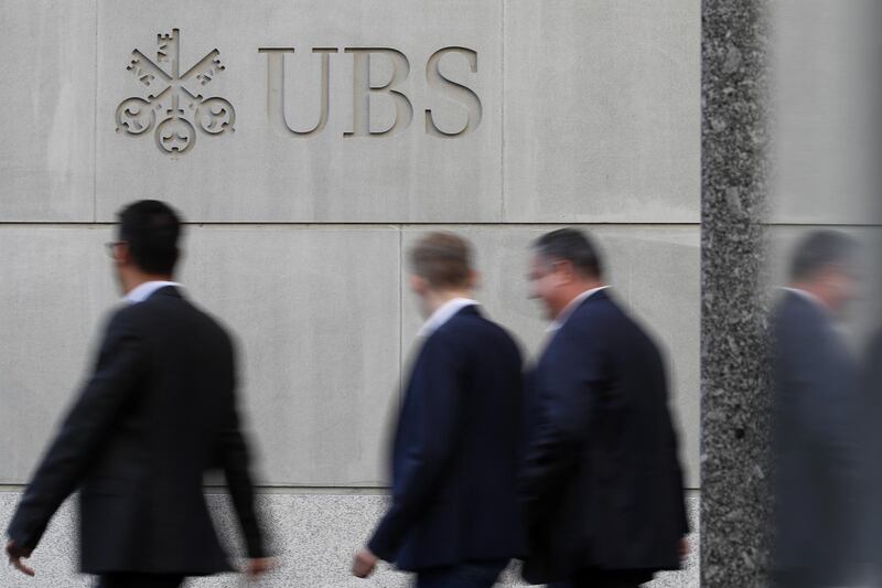 Pedestrians pass the UBS Group AG headquarters in Zurich, Switzerland, on Monday, Oct. 14, 2019. The spying scandal roiling Credit Suisse Group AG has also created a big headache at UBS a stone's throw away in Zurich: What to do about its star hire Iqbal Khan. Photographer: Stefan Wermuth/Bloomberg