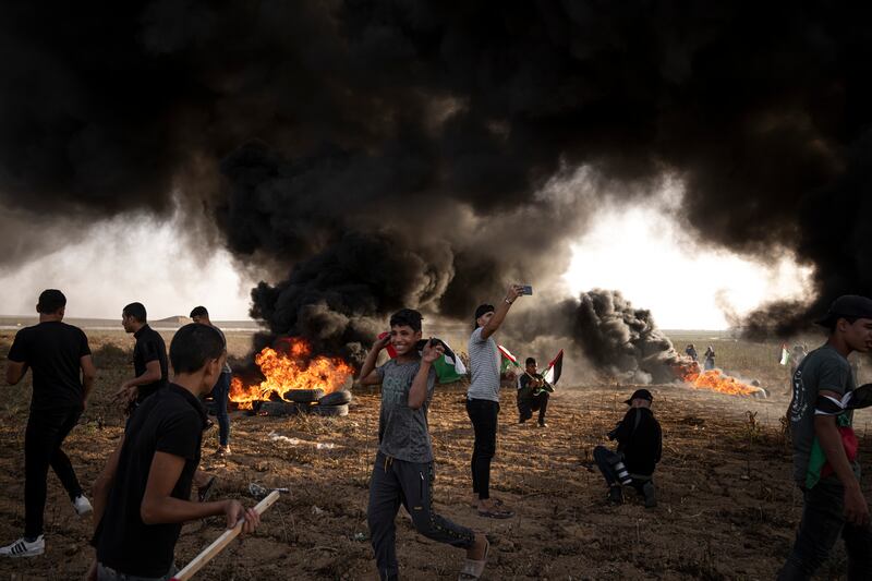 Palestinians burn tyres during a protest against Israeli military raids in the occupied West Bank, along the border fence with Israel, in east of Gaza City. Six Palestinians have been killed in the raids. AP