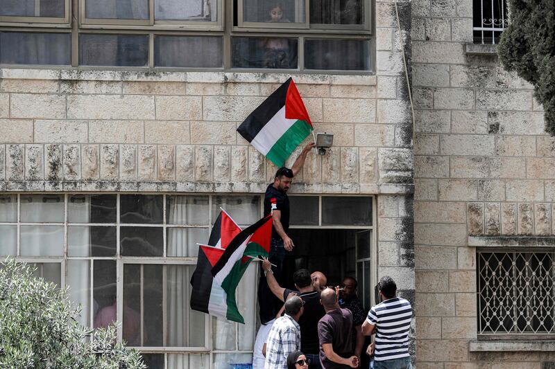 People gather with Palestinian flags outside the family home of the deceased Al Jazeera journalist. AFP