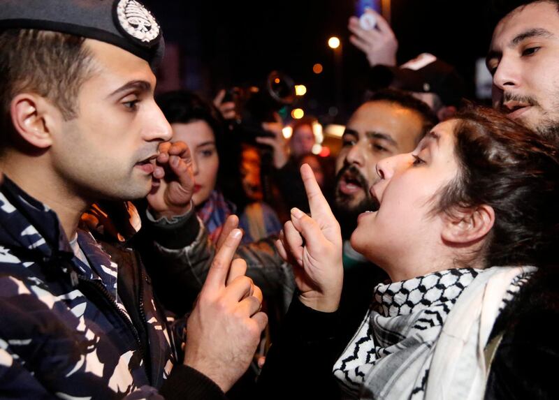 An anti-government protester, right, argues with a police officer, as protesters blocking a main road during ongoing protests against corruption, in Beirut,  Lebanon.  AP