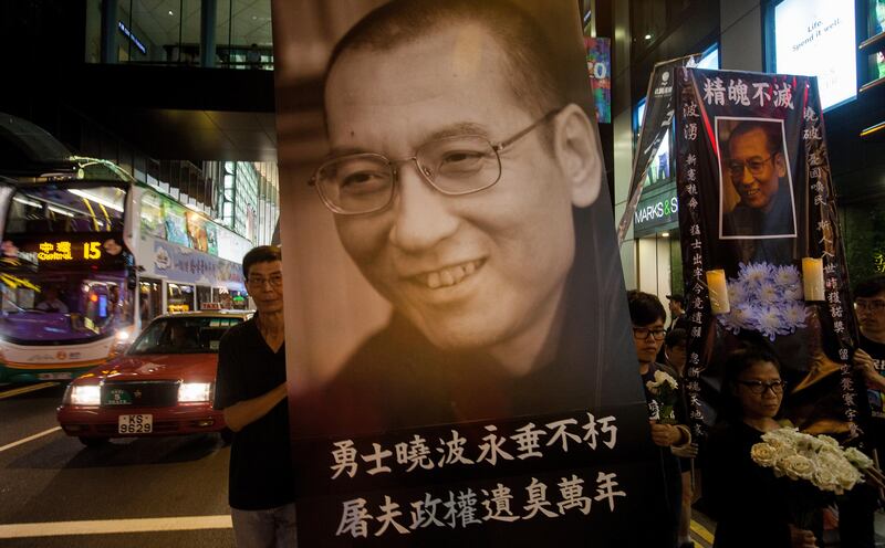 epa06089613 Members of the League of Social Democrats hold a large portrait of the deceased Chinese dissident and Nobel peace prize laureate Liu Xiaobo, as they march through the streets of Hong Kong to demand the release of Liu Xia, Liu Xiaobo's widow, Central District, Hong Kong, China, 15 July 2017. Human rights and pro-democracy activists in Hong Kong are calling on the Chinese government to release Liu Xia, the widow of Liu Xiaobo. According to media reports on 13 July citing official sources, Liu Xiaobo has died aged 61.  EPA/ALEX HOFFORD