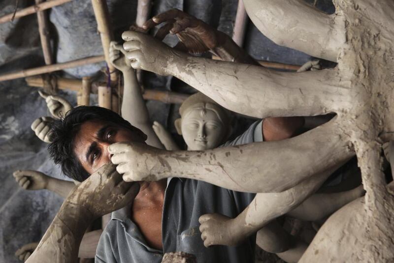 An artist prepares an idol at a workshop ahead of Durga Puja festival in New Delhi. The five-day Durga Puja festival that commemorates the slaying of a demon king by goddess Durga to mark the triumph of good over evil in Hindu traditions. Tsering Topgyal / AP photo