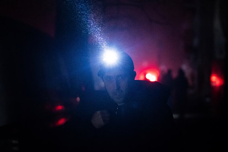 A man using a head torch to make his way around Kyiv. AP