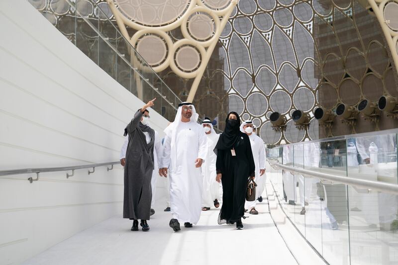 Sheikh Mohamed bin Zayed, Reem Al Hashimy and Noura Al Kaabi arrive at the UAE pavilion during a visit to Expo 2020 Dubai. Ryan Carter for the Ministry of Presidential Affairs