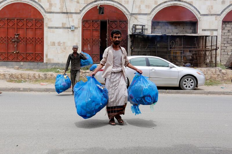 Sanitary workers remove rubbish from a street amid the spread of epidemics, in Sanaa, Yemen.  EPA