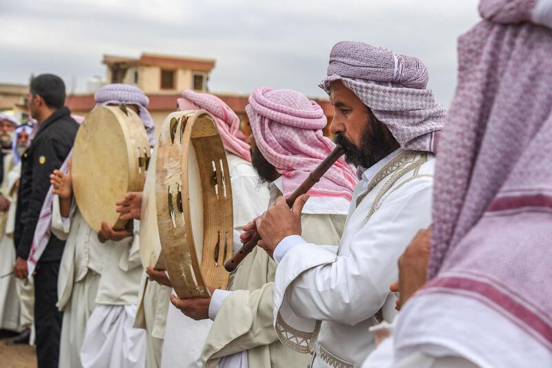 Men play the ney and tambourines in a procession during a mass funeral for Yazidi victims of ISIS in the northern Iraqi village of Kocho in Sinjar district. AFP