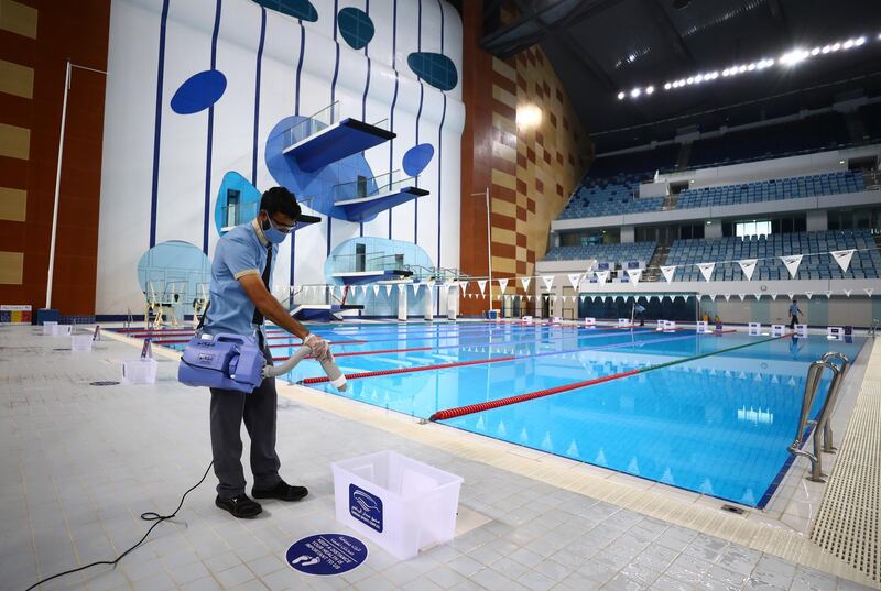 A worker is seen disinfecting the pool area in between training sessions at Hamdan Sports Complex in Dubai. Getty Images