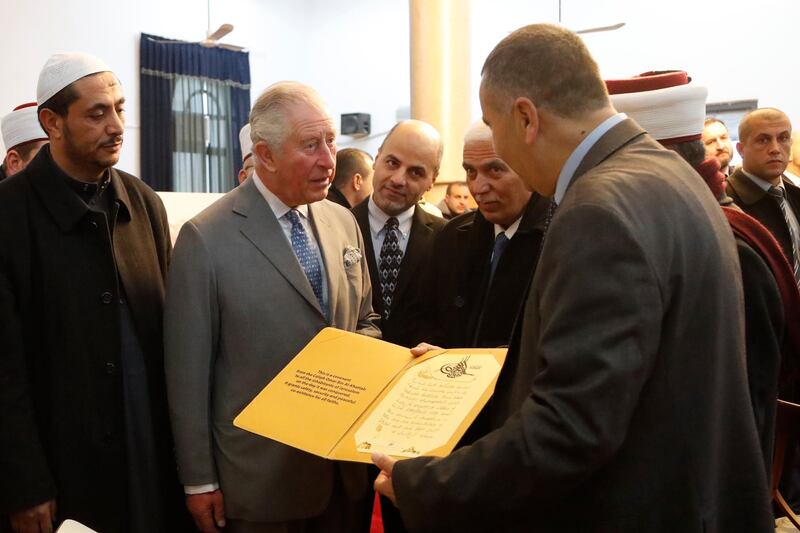 Prince Charles, center left, is presented a document as he visits the Mosque of Omar. AP Photo