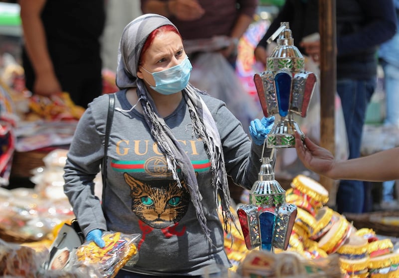 A woman wearing a protective face mask, amid concerns over the coronavirus buys traditional Ramadan lanterns in Cairo, Egypt, on April 12, 2020. Reuters