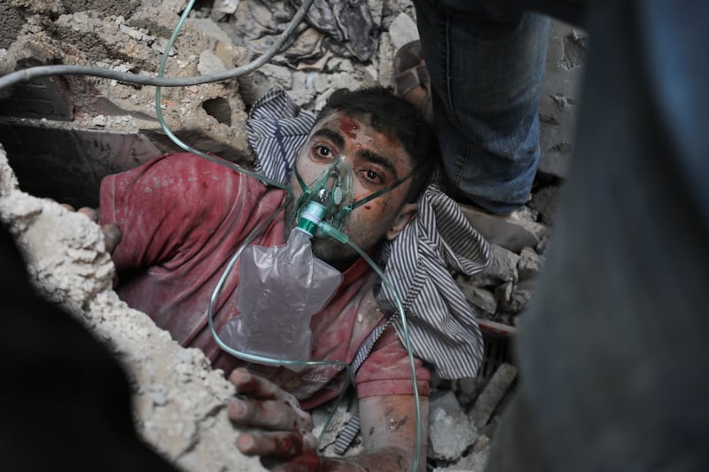 A man is given oxygen and pulled from the rubble in Nusseirat. AP