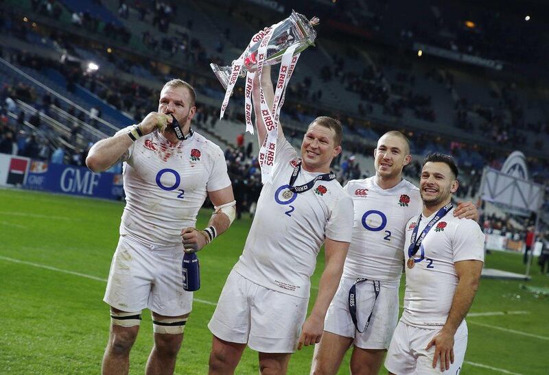 England’s hooker and captain Dylan Hartley (2nd L) holds the trophy next to England’s flanker Chris Robshaw (L), England’s fullback Mike Brown (2nd R) and England’s scrum-half Danny Care (R) as they celebrate winning the Six Nations rugby union tournament, after winning their match against France, at the Stade de France in Saint-Denis, north of Paris, on March 19, 2016. AFP PHOTO / THOMAS SAMSON
