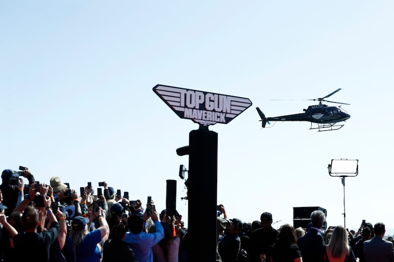 Fans watch as Tom Cruise arrives on a helicopter before attending the world premiere of 'Top Gun: Maverick' on the USS Midway in San Diego, California. EPA