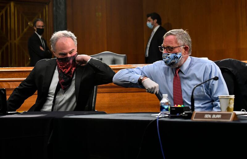 US Senators Tim Kaine and Richard Burr  greet each other with an elbow bump  in Washington, DC.   AFP