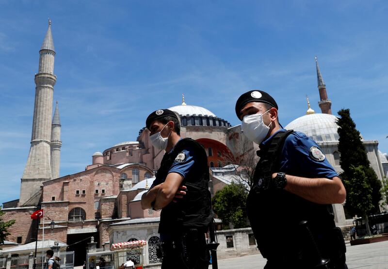 FILE PHOTO: Turkish police officers wearing face masks, with the Byzantine-era monument of Hagia Sophia, now a museum, in the background, patrol at touristic Sultanahmet Square following the coronavirus disease (COVID-19) outbreak, in Istanbul, Turkey, June 5, 2020. REUTERS/Murad Sezer/File Photo