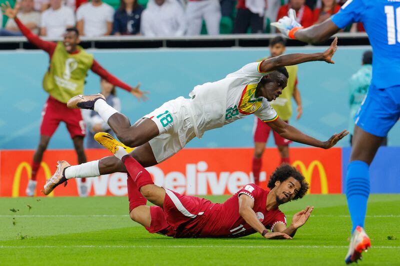 Senegal's Ismaila Sarr after barging over Akram Afif, but no penalty was given. AFP