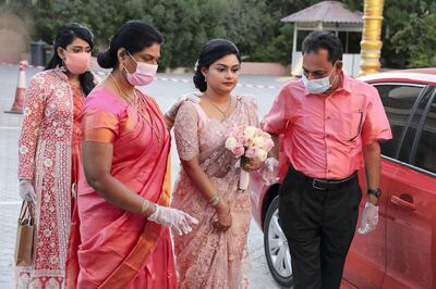 DUBAI, UNITED ARAB EMIRATES , October 26– 2020 :- Jubee Vargheese (bride) with her parents coming for the marriage ceremony held at the St. Thomas Orthodox Cathedral in Dubai. Relatives and friends were wearing protective face mask and gloves as a preventive measure against the spread of coronavirus and maintaining social distance during the ceremony.  (Pawan Singh / The National) For News/Online/Instagram. Story by Kelly