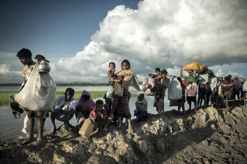 Rohingya refugees walk after crossing the Naf river from Myanmar into Bangladesh in Whaikhyang on October 9, 2017. 
A top UN official said on October 7 Bangladesh's plan to build the world's biggest refugee camp for 800,000-plus Rohingya Muslims was dangerous because overcrowding could heighten the risks of deadly diseases spreading quickly. The arrival of more than half a million Rohingya refugees who have fled an army crackdown in Myanmar's troubled Rakhine state since August 25 has put an immense strain on already packed camps in Bangladesh.
 / AFP PHOTO / FRED DUFOUR