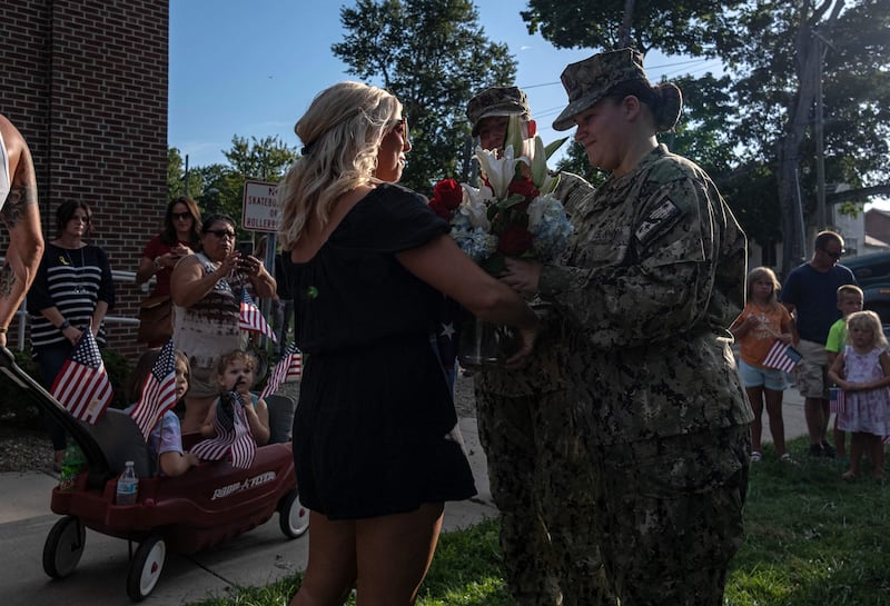 US Navy sailors hand flowers to the sister of Max  Soviak during a vigil in his honour at Edison Middle School in Berlin Heights, Ohio. AFP