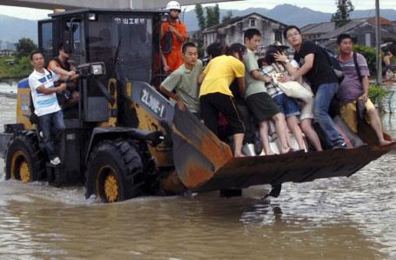 Residents of Cangnan in eastern China are rescued by a bulldozer on Monday after rains from Typhoon Morakot, which means emerald in Thai, caused a landslide. Entire blocks of buildings were washed away in the torrent.