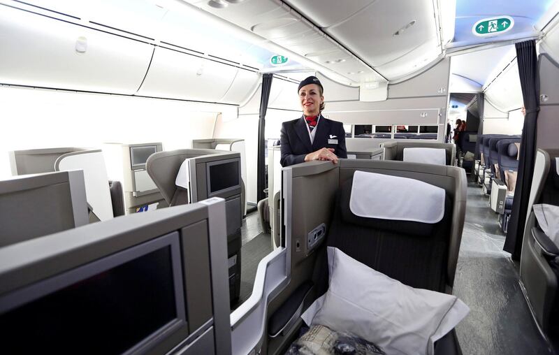 A British Airways (BA) flight attendant poses for a photograph in the 'Club World' class section of the company's new Boeing Co. 787 Dreamliner aircraft at Heathrow airport in London, U.K., on Thursday, July 4, 2013. British Airways will start regular services with the Airbus SAS A380 superjumbo a week earlier than planned after taking delivery of the first of 12 of the doubledeckers today. Photographer: Chris Ratcliffe/Bloomberg