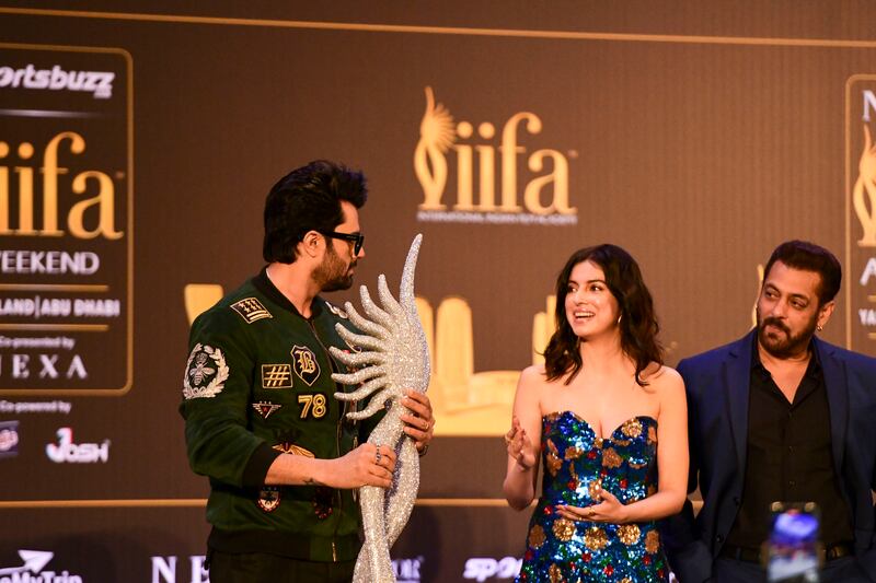 Manish Paul, Divya Khosla Kumar and Salman Khan on stage with a replica of the IIFA Awards statuette. 
