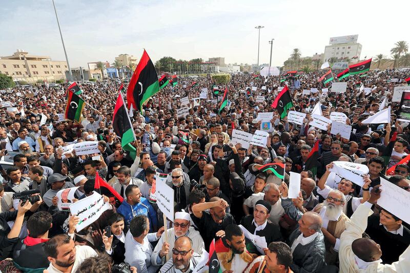 Libyans demonstrate in a street in the capital Tripoli to demand the withdrawal of all  armed militias from the capital on November 22, 2013. Residents of Libya's capital were turning out Friday to press militias remaining in the city to follow others and withdraw, aiming to keep up the momentum following deadly clashes last weekend. Many of the groups have long rejected government calls to lay down their arms or integrate into the armed forces, triggering the frustration of Libyans who once hailed them as heroes for toppling Kadhafi. AFP PHOTO/MAHMUD TURKIA (Photo by MAHMUD TURKIA / AFP)