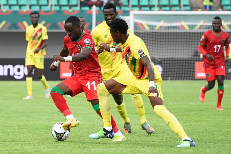 Malawi forward Frank Mhango, left, fights for the ball with two Zimbabwe players. AFP