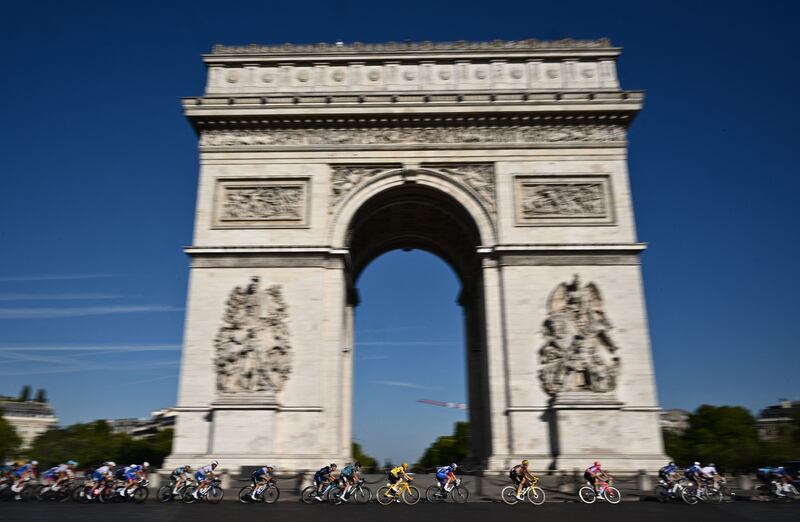 Jonas Vingegaard and the peloton pass the Arc de Triomphe on the Champs-Elysees in Paris. AFP