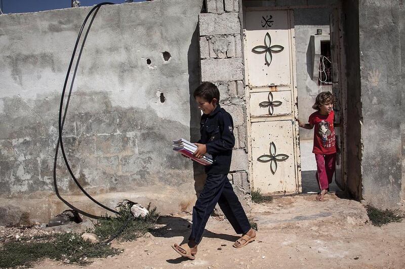 Abdo Al Fikri, 12, walks to school from his family home in Madaya village as classes resume in schools in the Idlib province for the first time in a year.  AP