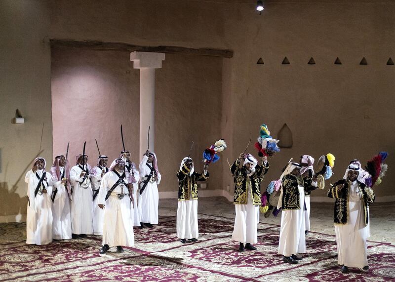 RIYADH, KINGDOM OF SAUDI ARABIA. 26 SEPTEMBER 2019. 
Saudi traditional dance performance inside At-Turaif district in Ad-Dariya.

At-Turaif was founded in the 15th century, with much influence owed to the Najdi architectural style of Arabia. In the mid-18th century, the sprawling mud-brick city spawned the dynasty of Al Saud, who had lived in Ad Diriyah since the 15th century. 

The largest single structure in the city is Salwa Palace, which extends over approximately 10,000 square metres and consists of seven main units. The palace contains the Ad Diriyah museum, with more museums set to come.
Former villa residences that once housed families in 18th-and 19th-century At-Turaif have been converted into a souq, plus an array of cubby­hole areas where demonstrations of traditional crafts now take place – calligraphy, medicine, carpet weaving and the making of weapons are among the attractions. Again, all the staff are Saudis.

(Photo: Reem Mohammed/The National)

Reporter:
Section: