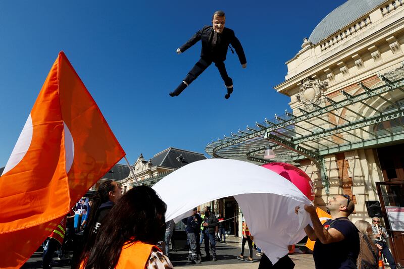 A puppet depicting French President Emmanuel Macron is tossed into the air by workers on strike in Nice. Reuters