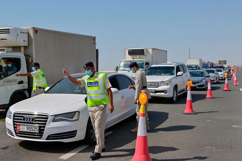 Emirati security forces man a checkpoint at the entrance of Abu Dhabi, on the highway linking Dubai to the capital, on June 2, 2020, after authorities cordoned off the city for a week to rein in the novel coronavirus.  / AFP / Giuseppe CACACE
