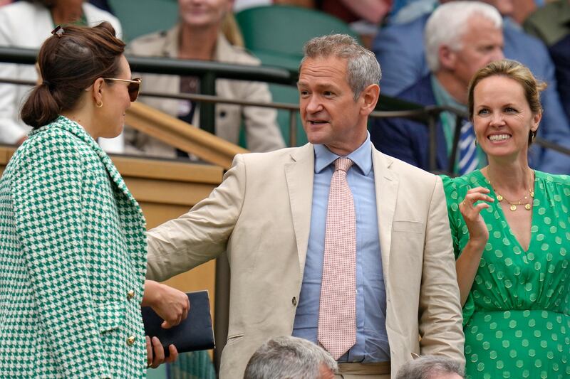 TV host Alexander Armstrong arrives to take his seat to watch a singles match in London. AP