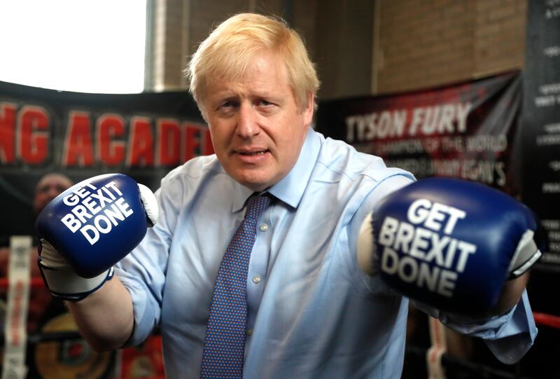 Mr Johnson poses for a photo wearing boxing gloves during a stop on his general election campaign trail in Manchester, in November 2019. Getty Images