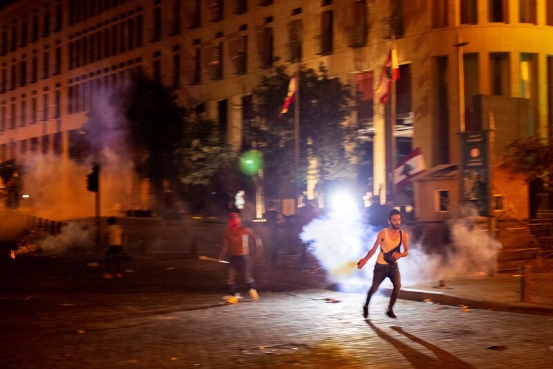 A protester throws back a tear gas canister during a demonstration against the political elites who have ruled the country for decades. AP