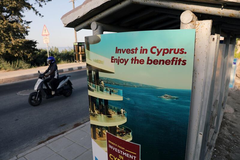 FILE PHOTO: A person riding a scooter passes an advertisement near Paphos, Cyprus October 12, 2019. Picture taken October 12, 2019.  REUTERS/Stringer/File Photo