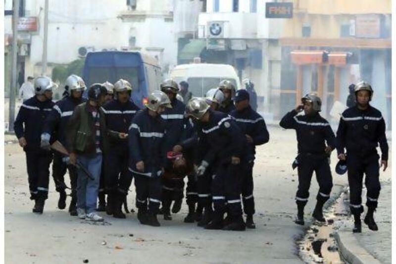 Rescue workers evacuate unidentified victims of violence on stretchers in Tunis yesterday. A protester was fatally shot and an American journalist was hit in the leg by police gunfire Thursday as rioting youths clashed with authorities in Tunisia's capital for the second day.