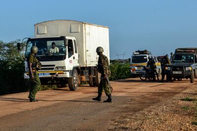 Kenyan police officers check vehicles on a road after a bus, travelling from the coastal region of Lamu to the town of Malindi, was ambushed by gunmen in Lamu county, southeast Kenya, on January 2, 2020. At least three people were killed near Kenya's southeastern border with Somalia on January 2, 2020 when gunmen ambushed the bus they were travelling in, a government official said. Attacks along the Kenya-Somalia border by Al-Shabaab militants are common, notably targeting security forces with roadside bombs. / AFP / STRINGER
