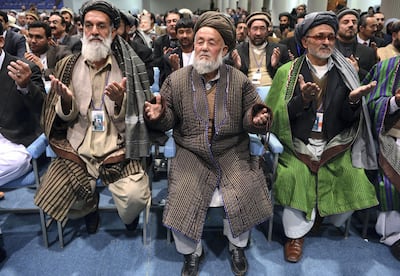 Members of the Afghan loya jirga, a meeting of around 2,500 Afghan tribal elders and leaders, pray on the last day of the four-day long loya jirga in Kabul on November 24, 2013.  An Afghan grand assembly endorsed a crucial security agreement allowing some US troops to stay on after 2014, although President Hamid Karzai set conditions for signing the deal.   AFP PHOTO/Massoud HOSSAINI (Photo by MASSOUD HOSSAINI / AFP)