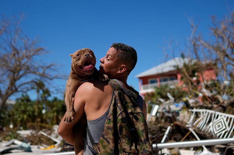 Rescuer Eduardo Tocuya hopes to reunite a dog with its owners after Hurricane Ian hit Fort Myers Beach in Florida. AP