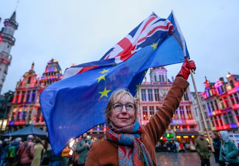 A woman holds a European flag and a Union Jack flag on the Grand Place in Brussels, Belgium.  EPA