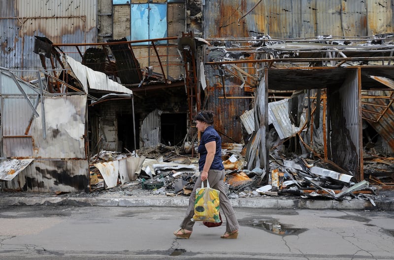 A woman walks past a destroyed market near a railway station in Donetsk. Reuters 